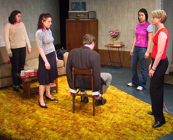 Ritchie (John Goode) waking up after being tied down by the girls (Meredith Lucio, Trista Dellyn, Elizabeth Wong, and Kerry Sullivan).