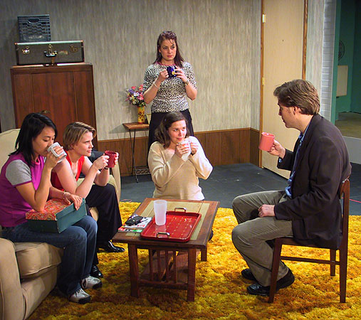 Ritchie (John Goode) takes his first sip of drugged tea while the girls (Elizabeth Wong, Kerry Sullivan, Trista Dellyn, and Meredith Lucio) look on.