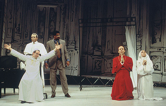 The Pope (Paul Niebanck) is stuck with arms outstretched as
						Pialli (James Shanklin) and Sister Gabriella (Meg Brogan) pray
						and Professor Ridolfi (Obi Ndefo) looks on.
